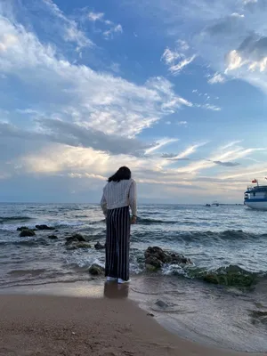 девушка босяком стоит на берегу моря и смотрит вдаль . barefoot girl  standing on the beach and looks into the distance Stock Photo | Adobe Stock