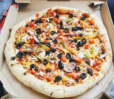 A staff member of US pizza chain Domino Pizza hands a pizza to a customer  in the chain's first German chain store in Berlin, Germany, 04 November  2010. Domino Pizza targets an