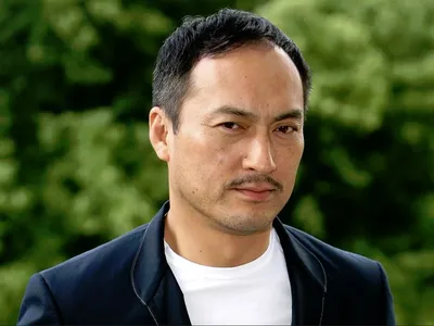Мужчина (40-45 лет) азиатской внешности с хорошей растяжкой