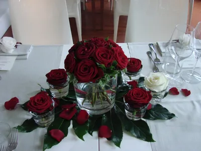 Фото Букет белых и красных роз в вазе, одна роза лежит на столе