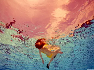 Рыжая девушка в каблуках плавает на спине — Фото аватарки
