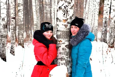 Девушка одела в теплых одеждах зимы и шляпе представляя в модели леса зимы  с красивой улыбкой около рождественской елки Стоковое Изображение -  изображение насчитывающей волосы, одежды: 104243213