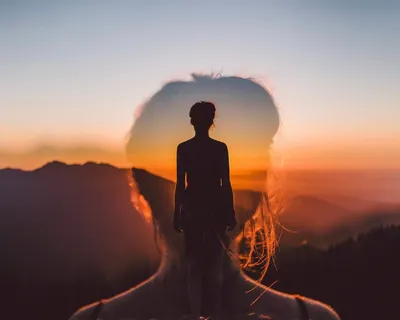 девушка стоит на высокой горе спиной с поднятой рукой на фоне красивого  вида на море и горы Stock Photo | Adobe Stock