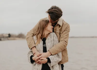 Мужчина и женщина обнимаются на берегу залива · Бесплатные стоковые фото