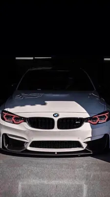 Белый автомобиль bmw x5 на фоне туч - обои на телефон