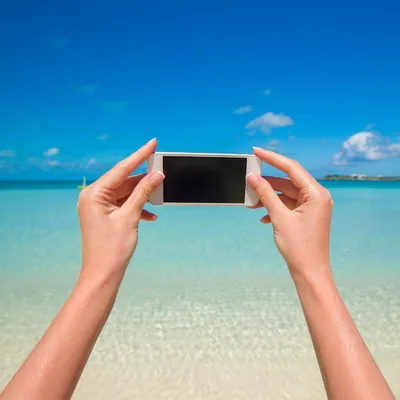 Крупным планом телефон фон бирюзовое море на курорте wxotic | Премиум Фото