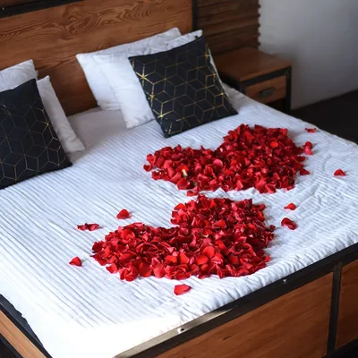Большая кровать с лепестками роз в спальне, украшенная для валы 3jpg |  Премиум Фото