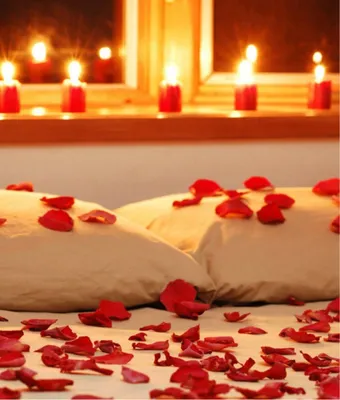 Медовый месяц кровать с лепестками роз стоковое фото ©Ruslan 19551727