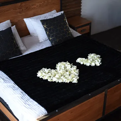 Кровать с двумя бокалами вина и лепестками роз на ней | Премиум Фото