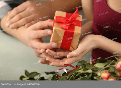 Романтический сюрприз. Черный человек, представляющих подарок к девушке на  ужин в ресторане Стоковое Фото - изображение насчитывающей черный, пары:  209214350