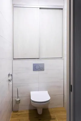 Зашивка бойлера и вентиляции в туалете над инсталляцией с двумя распашными  дверцами и открытой полкой для принадлежностей - на заказ в Москве