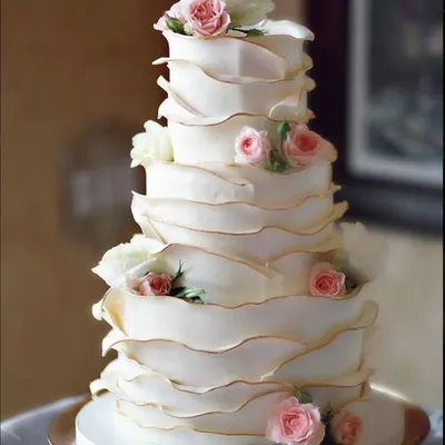 Свадебный торт с кремовым покрытием белого и кремового цвета и цветами