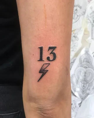 Tattoo of the number \"13\" done on the tricep.