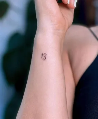 Tattoo of the number \"13\" located on the bicep.