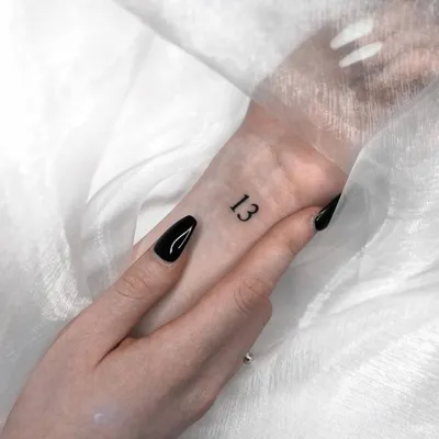 Number \"13\" tattooed on the wrist.