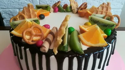 Изображение торта с разнообразными фруктами вокруг