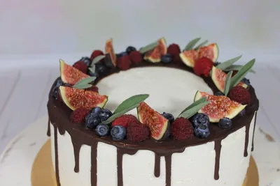 Изображение торта с фруктами и цветами на верхушке