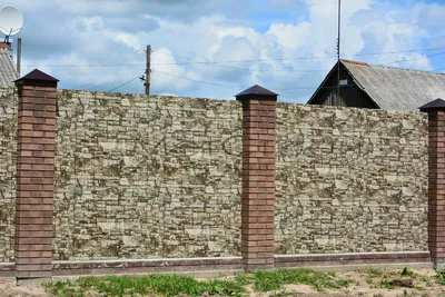Забор из профнастила с рисунком камня на металлических столбах с воротами и  калиткой.