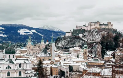 Beautiful view of the historic city of Salzburg with famous Salzburg  Cathedral in winter, Austria.Christmas trees with red Christmas balls  against the background of the winter Salzburg. фотография Stock | Adobe  Stock