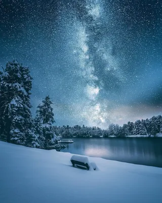 Фото Огромное звездное небо раскинулось над заснеженной местностью